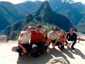 Personas en cuclillas en la parte de los andenes de la parte superior de Machu Picchu