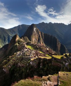 Panoramic view of Machu Picchu from the upper terraces, with lush mountains in the background and the Inca citadel in the foreground